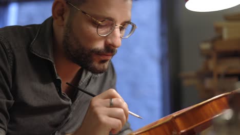 luthier se centró en el barnizado del violín en el taller