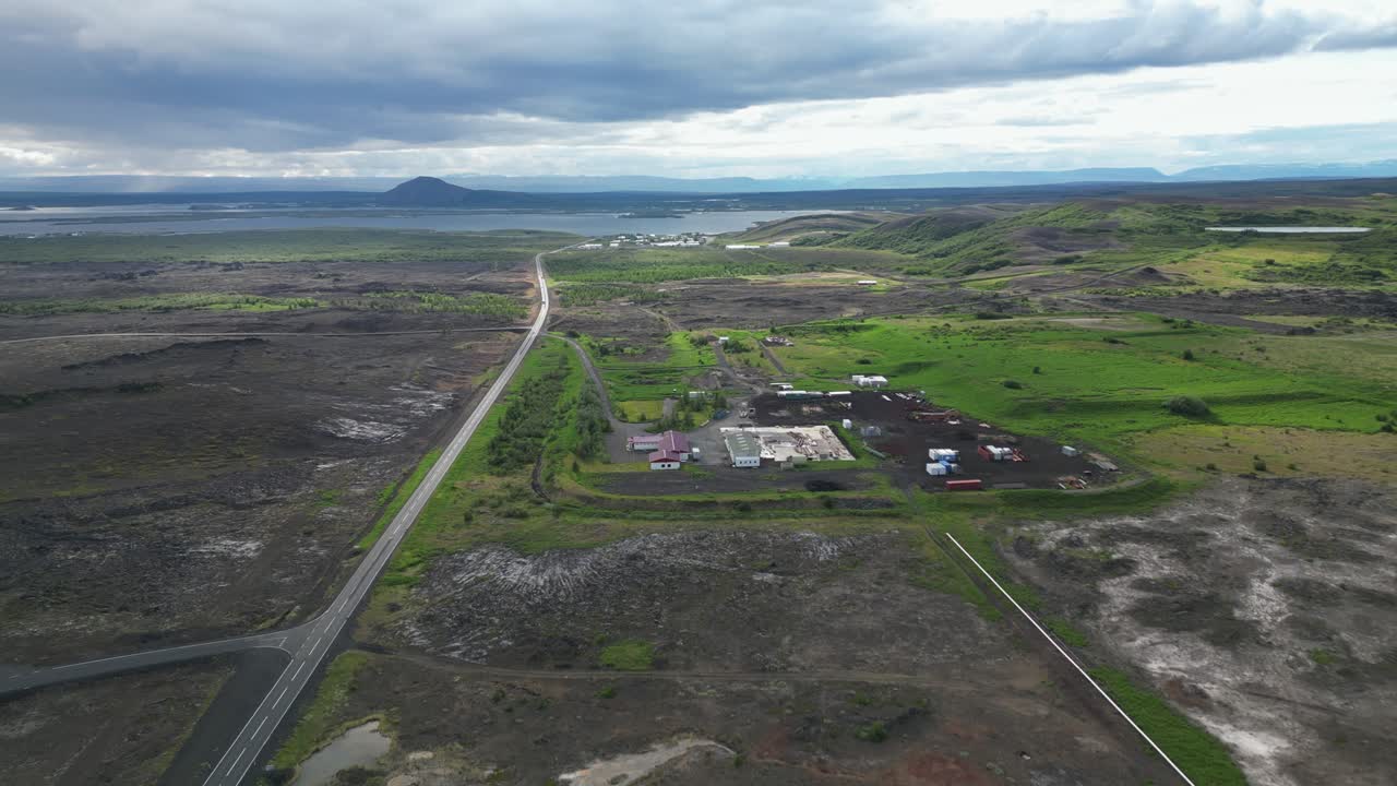 conduciendo pacíficamente a través del campo islandés más allá de las granjas y hacia el lago