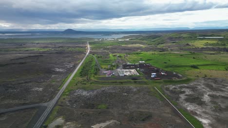 conduciendo pacíficamente a través del campo islandés más allá de las granjas y hacia el lago
