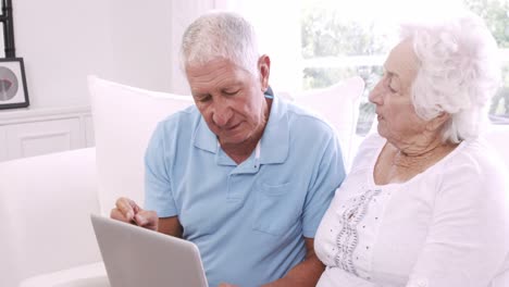 una pareja de ancianos usando una computadora portátil y hablando