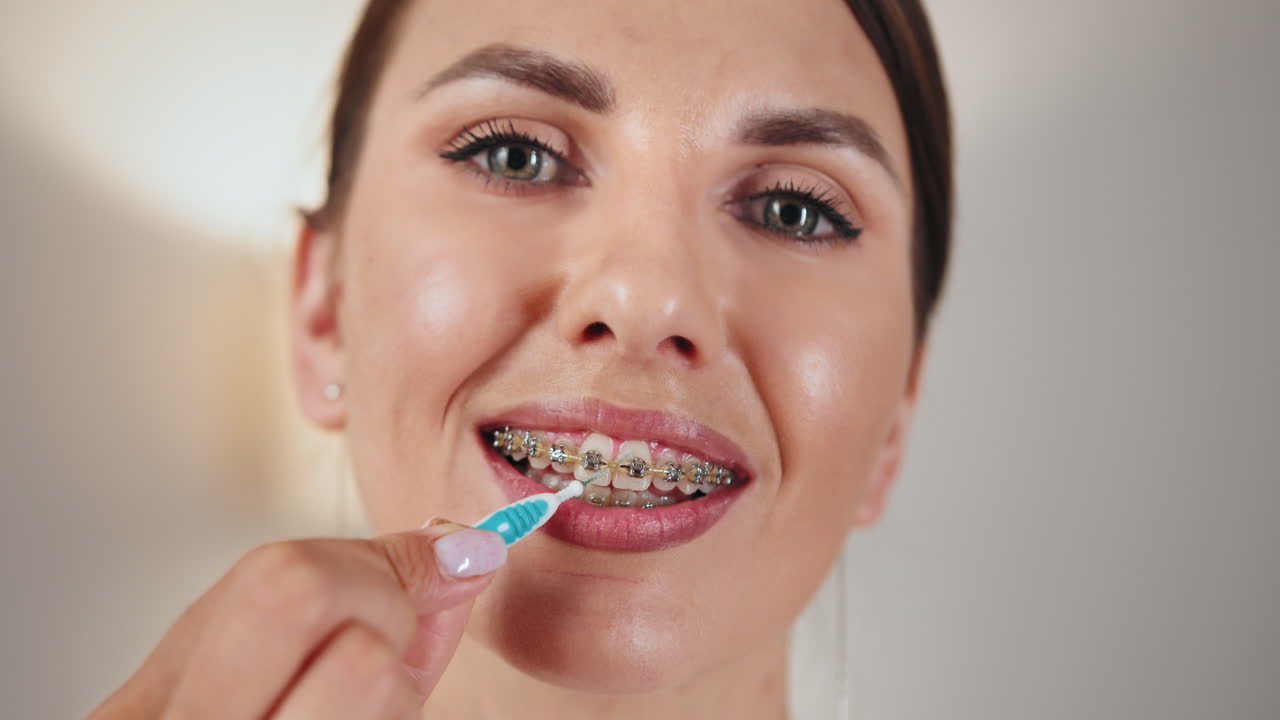 Woman Cleaning Teeth with Braces