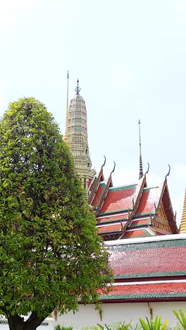 a tranquil scene at wat phra kaew, showcasing lush greenery and iconic temple spires under bright daylight in bangkok, thailand