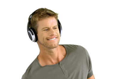 hombre atractivo con auriculares escuchando música en fondo blanco