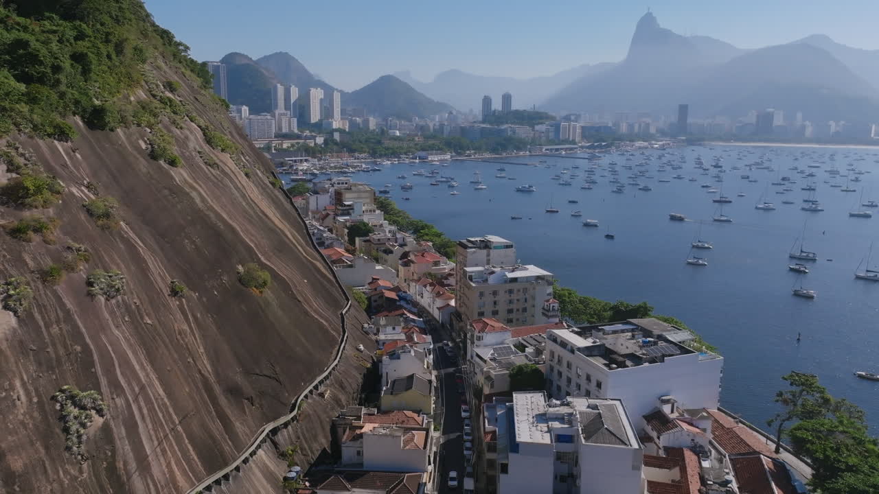 imágenes aéreas siguiendo la curva de morro da urca con botafogo en el fondo en río de janeiro