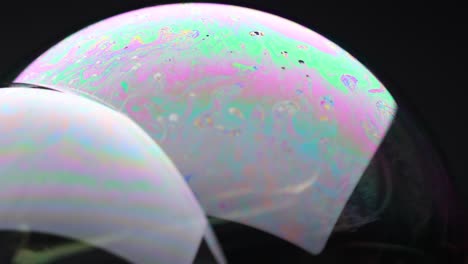 vibrant soap bubble displays shifting colors and reflections against a dark background, showcasing dynamic light and fluid movement