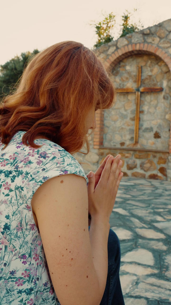 Donna prega al Calvario con crocifissi all'aperto per chiedere la cura dei malati