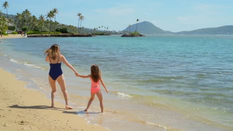 Mother-and-daughter-walking-on-the-beach-4k