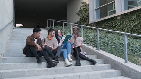 Diverse students doing homework on steps
