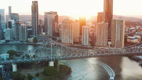 Tiro-De-Cierre-Perfecto-De-Bienes-Raíces---Puesta-De-Sol-De-La-Ciudad-De-Brisbane-Desde-El-Cielo-Con-Puente-De-Historia-Y-Edificios-Detrás