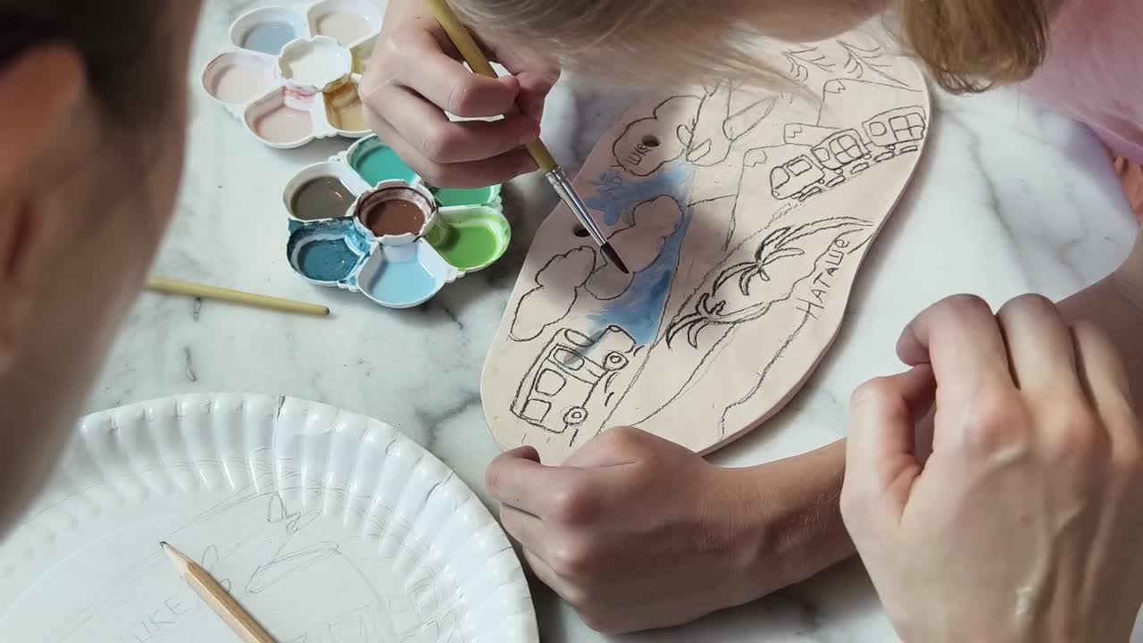 niños pintando cerámica con un tema hawaiano