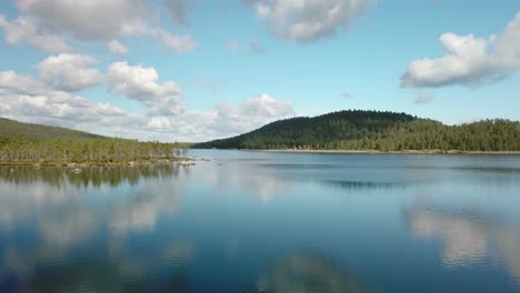 Vorwärts-Gerichtete-Luftaufnahme-Aus-Geringer-Höhe-über-Einem-Ruhigen-See-In-Finnland,-In-Dem-Sich-Wolken-Spiegeln