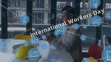 Animation-of-international-workers-day-text-over-caucasian-businesswoman-in-office