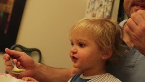 padre alimentando al bebé en casa en 4k. padre nutriendo al niño pequeño