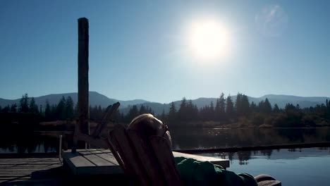 man-sitting-on-dock-at-sunset