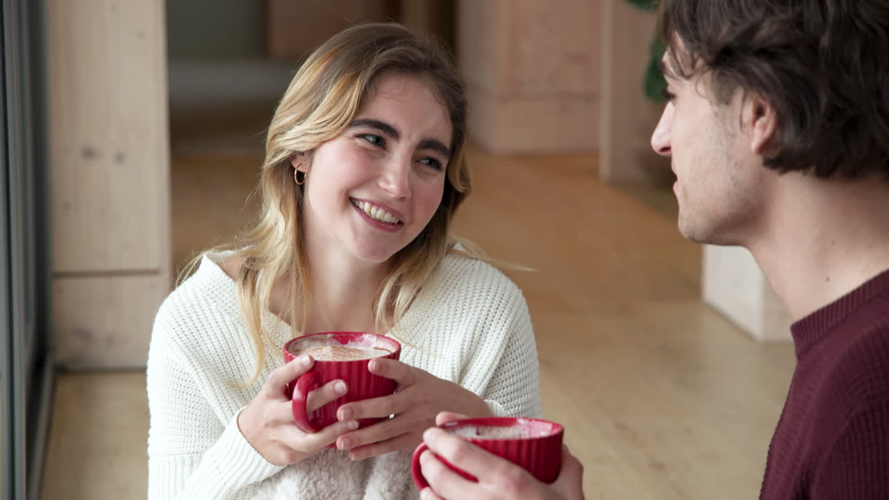 Smiling couple enjoying hot cocoa together at home during Christmas season