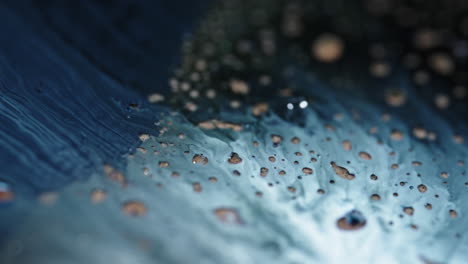 blue and white liquids mix and form abstract patterns in a close-up macro view, creating a fluid texture