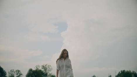 woman walking against cloudy sky