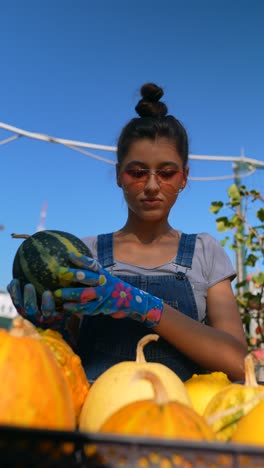 mujer cosechando calabazas