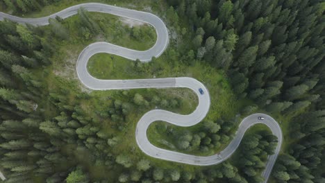 città in basso vista di tracciamento aereo di un'auto sportiva che guida su tortuose strade tedesche