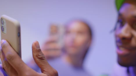 fotografía de estudio de cerca de amigos jóvenes de la generación z sentados en el sofá compartiendo publicaciones en las redes sociales en teléfonos móviles 9