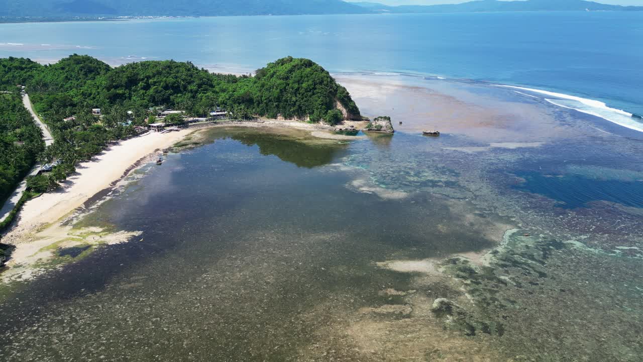 Stunning aerial drone shot of white sand beach resort and lagoon during daytime and low tide in Catanduanes, Philippines