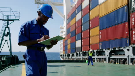 workers inspecting cargo containers on a container ship