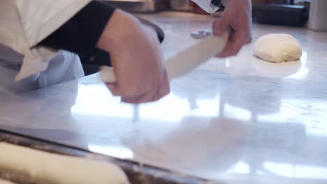 chef formando masa de pan en la mesa de cocina en el restaurante