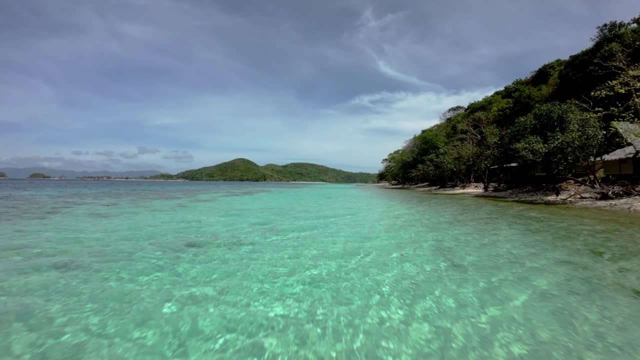 fpv drone volando sobre aguas turquesas cristalinas en la costa de coron, palawan - filipinas
