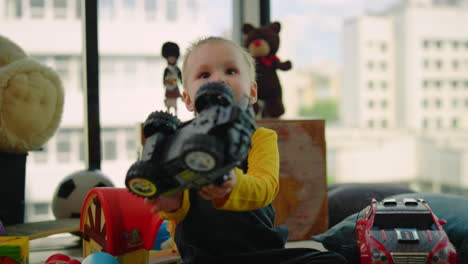 Porträt-Eines-Kleinen-Jungen,-Der-Drinnen-Spielzeugauto-Spielt.-Nettes-Kind,-Das-Zu-Hause-Spaß-Hat.