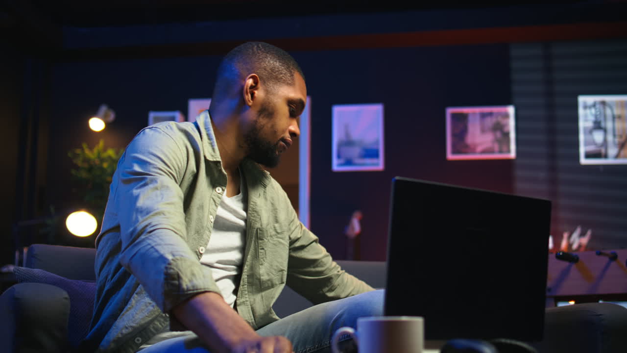 Vertical Video Relaxed black man scrolling on his smartphone in a comfortable space