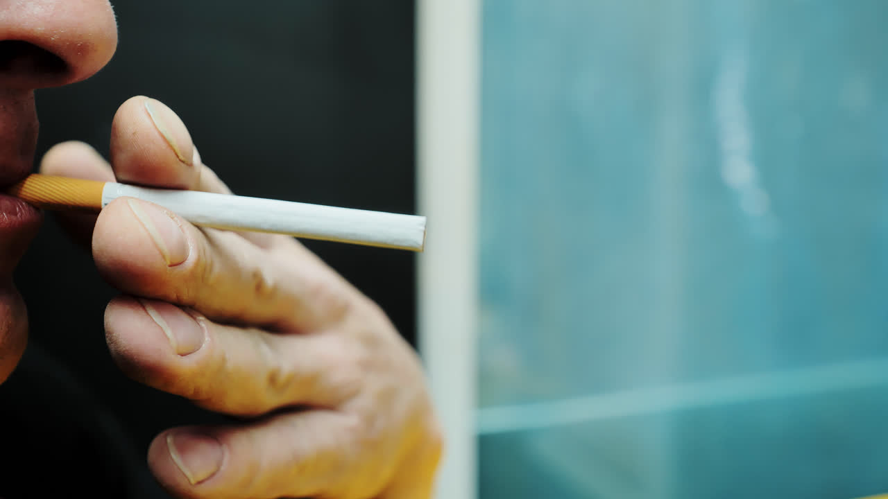 Rough worker's hands ignite cigarette in gritty close-up breaktime smoking scene
