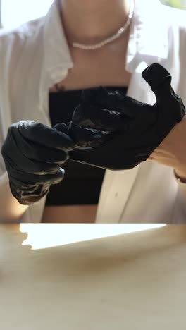 person putting on black gloves