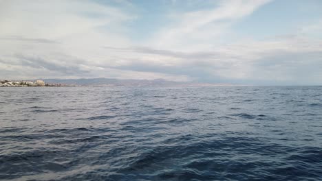 View-from-boat-on-sea-of-Costa-Del-Sol-Malaga-calm-ocean-water-surface-with-small-fast-waves