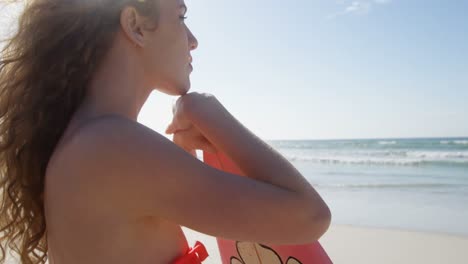 surfista de pie con una tabla de surf en la playa 4k