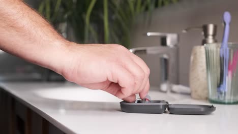 adult man taking hearing aids from the bathroom