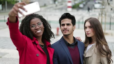 Two-women-and-man-making-selfie-outside,-posing,-smiling