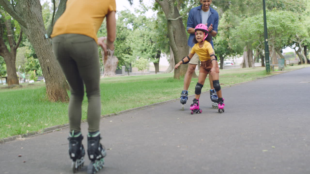 Adorable girl learning to rollerskate with parents