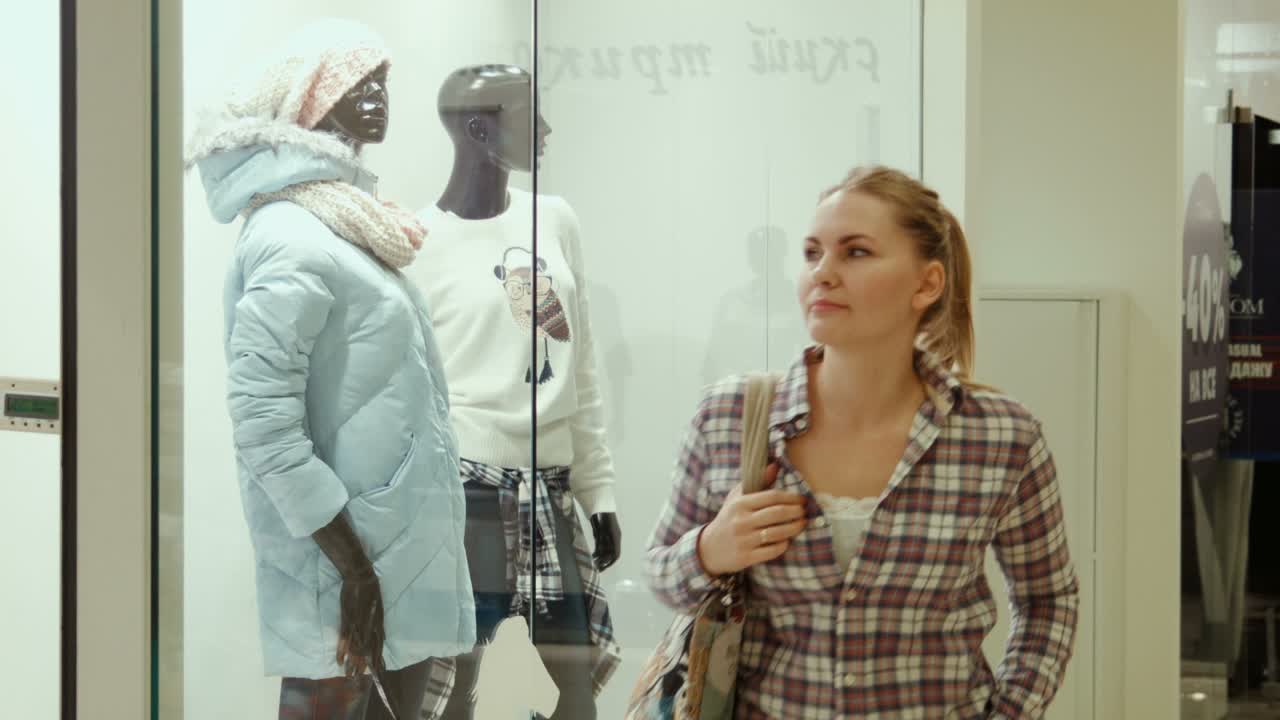 The Girl Looks At a Show-window Of Clothing Store