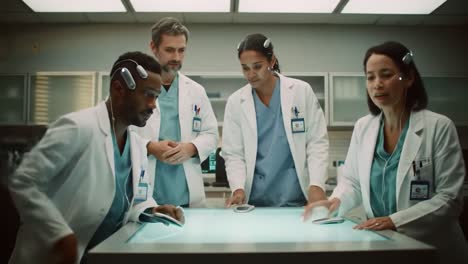 four healthcare workers discuss patient cases in a high-tech environment. they are focused on their tablets and teamwork, showcasing the importance of collaboration in modern medicine.
