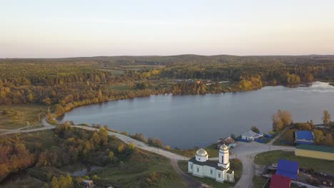 aerial view of a russian village with a church and lake