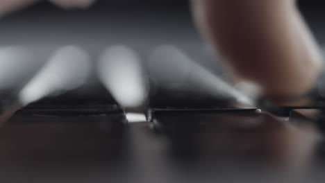 extreme close-up of finger pressing keys on laptop keyboard