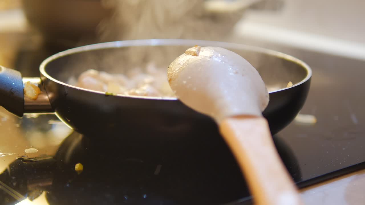 Close-up of a pan with food cooking on a stovetop