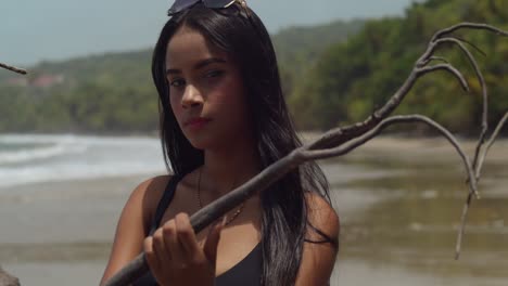 junges mädchen am strand, gesichtsbehandlung aus nächster nähe, mit wehenden haaren im wind und meereswellen, die im hintergrund an die küste krachen