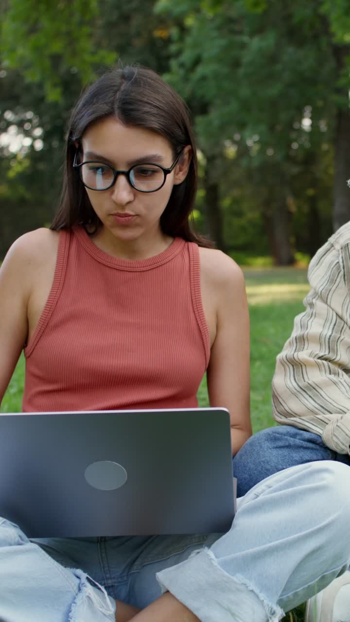 amigos colaborando en una computadora portátil en un parque