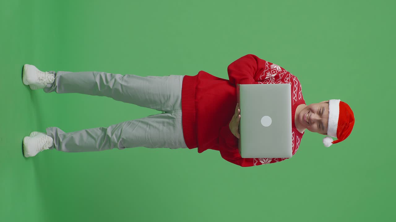 hombre en suéter de navidad con computadora portátil