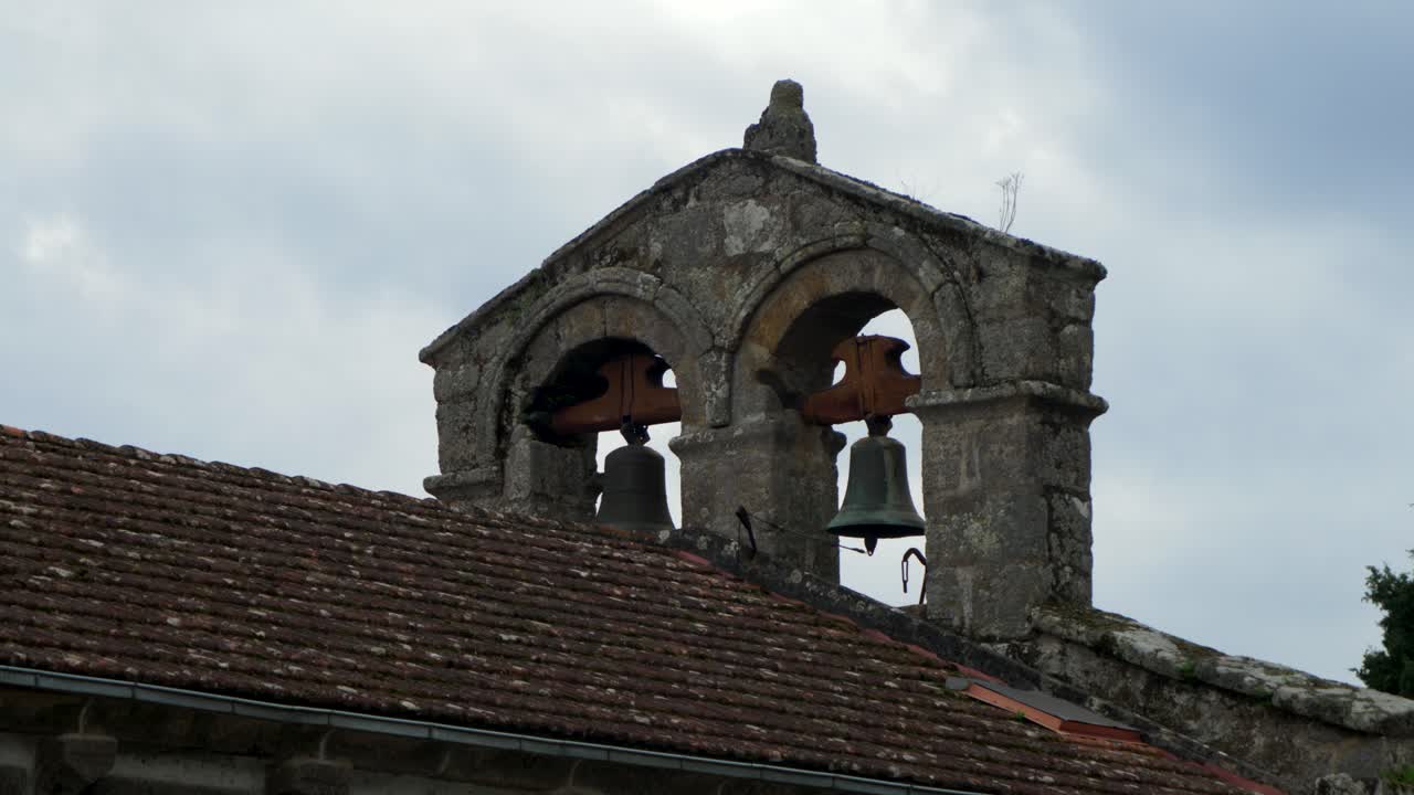 Santiago de Gustei church belfry in Coles, Ourense with bell tower and rural surroundings, detailed establishing view