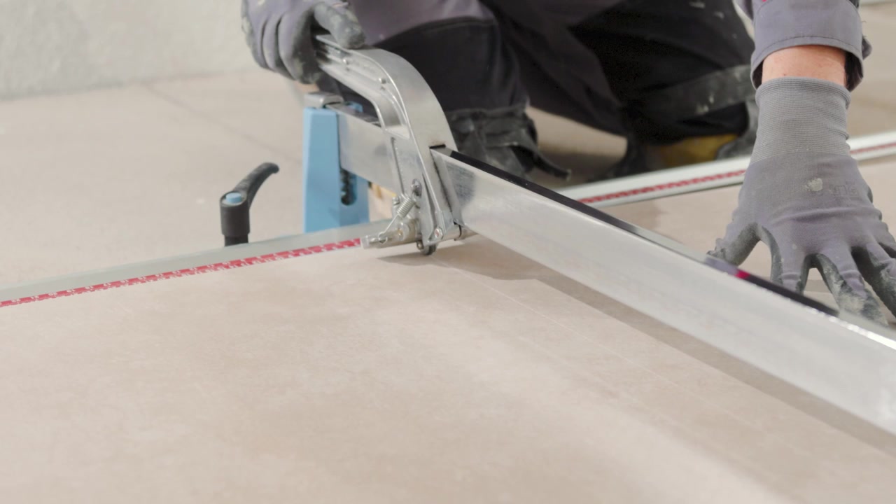 Professional tiler cutting a tile with a big cutting tool. Renovating your house.