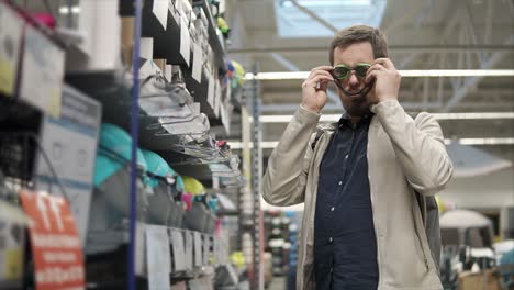 man trying on sunglasses in a sporting goods store