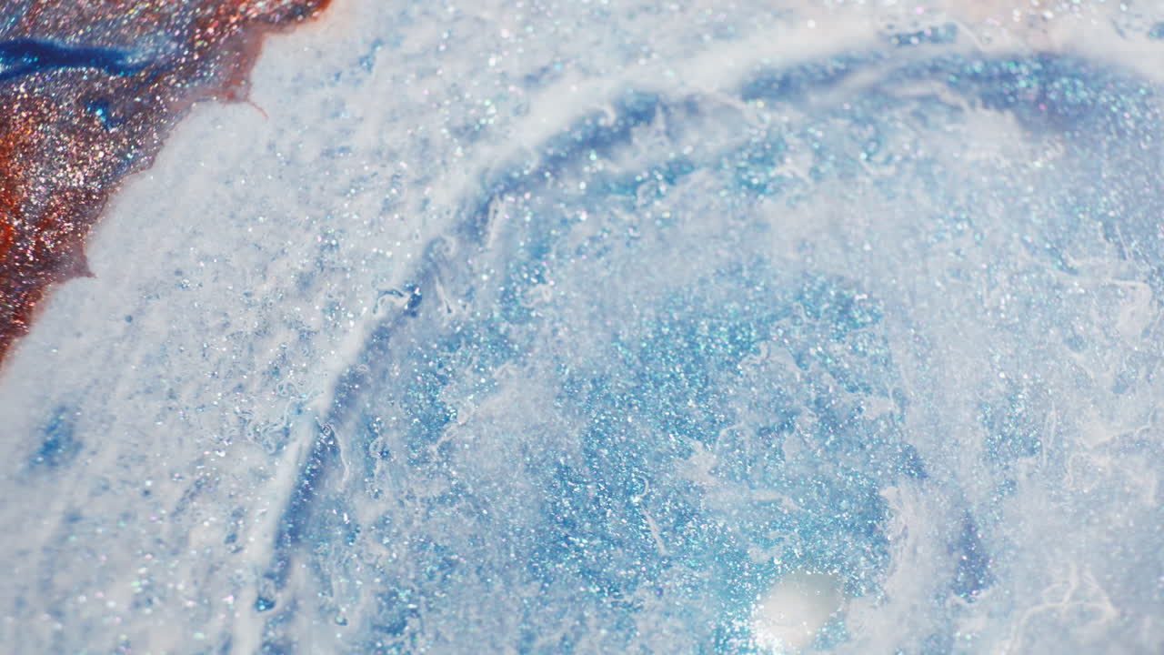 Bright turquoise ink spreading in a thick fluid. Macro close-up