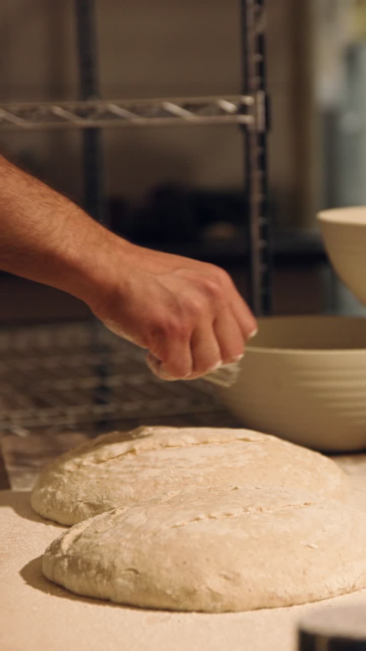 Baker's Hand Sprinkling Flour on Fresh Bread Dough